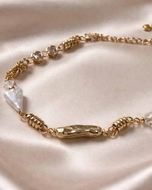 Gold bracelet with pearls on a satin surface