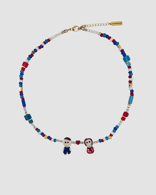Necklace with colorful beads and small figures on a light gray background
