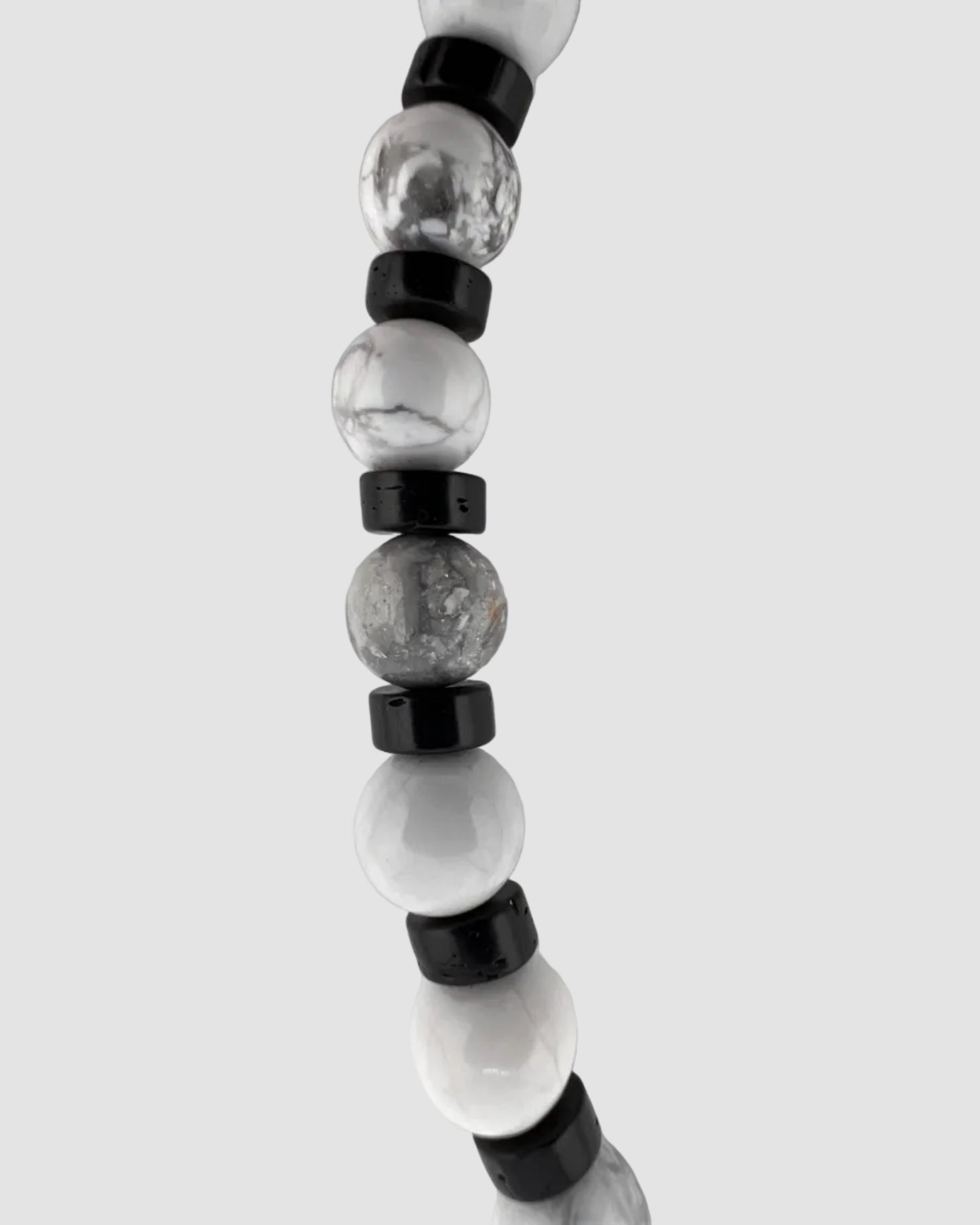 Beaded necklace with black and clear beads on a light gray background