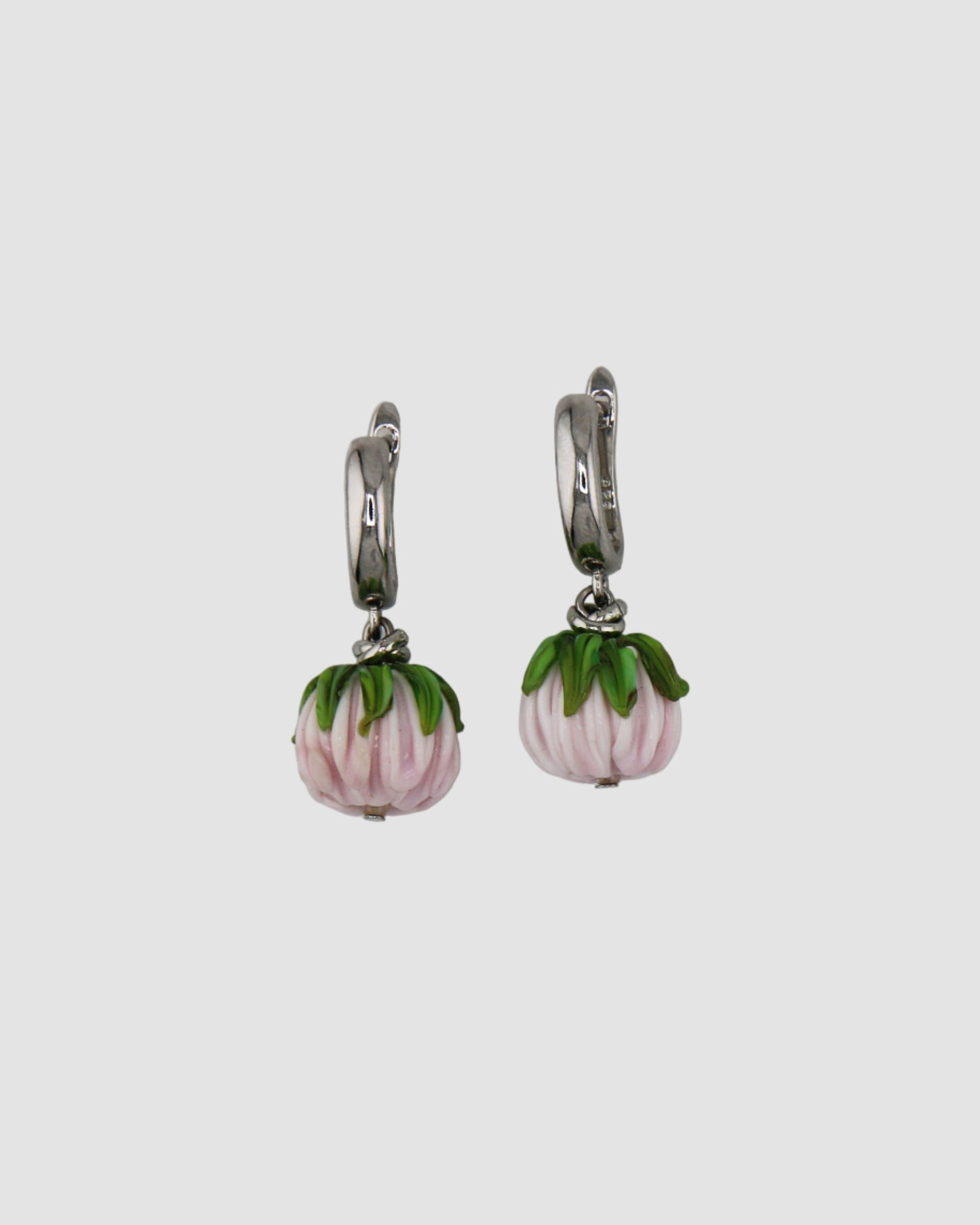 Pair of earrings with flowers on a light gray background