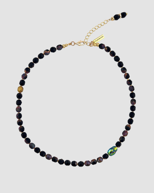 Necklace with black beads and a gold clasp on a white background