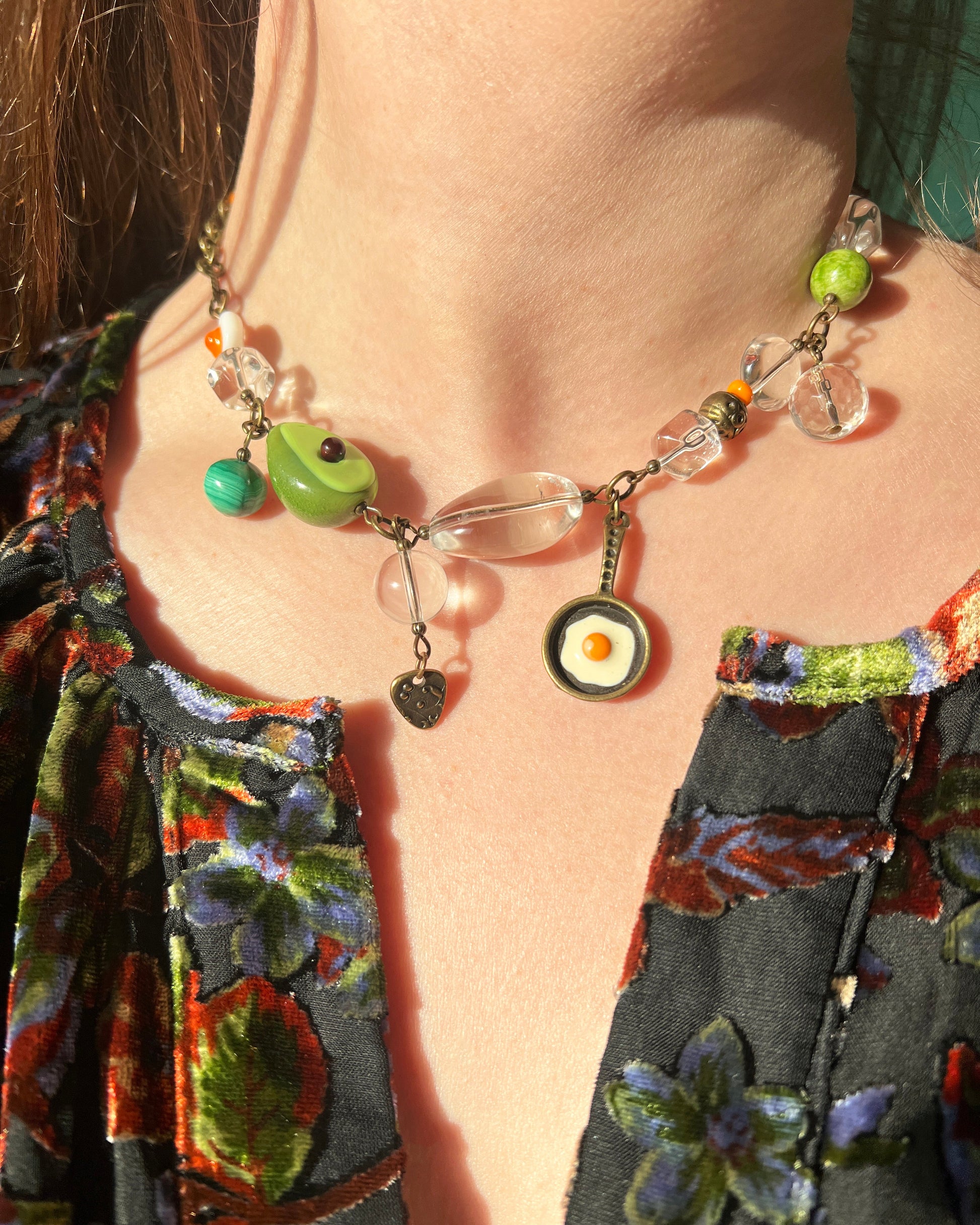 Close-up of a colorful beaded necklace worn by a person with a patterned garment.