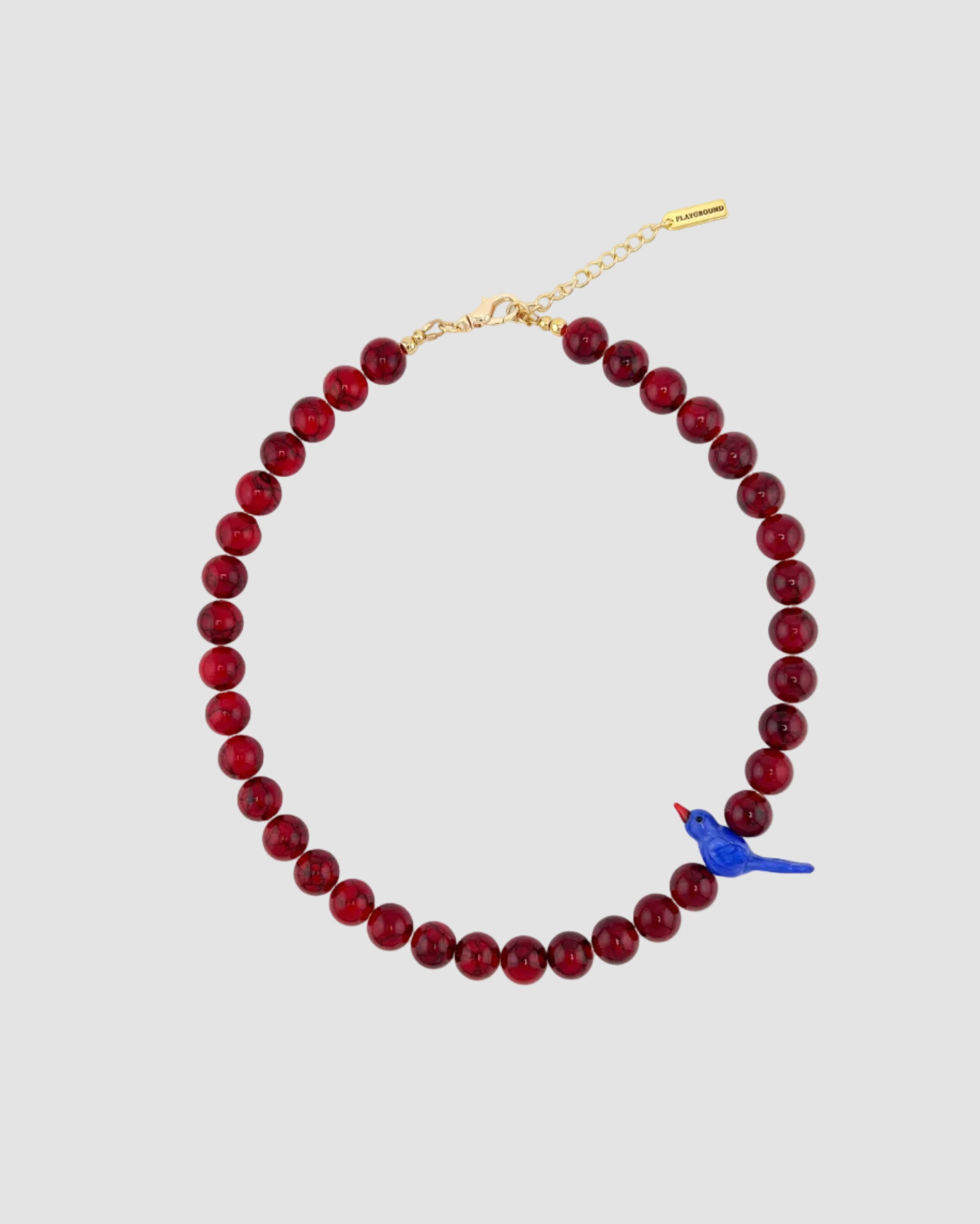 Red beaded necklace with a blue bird charm on a white background