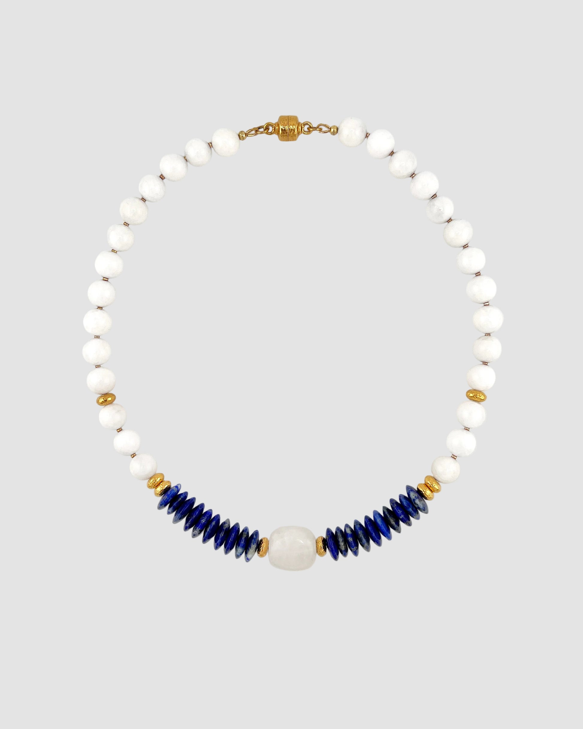 Necklace with white beads and blue accents on a light gray background