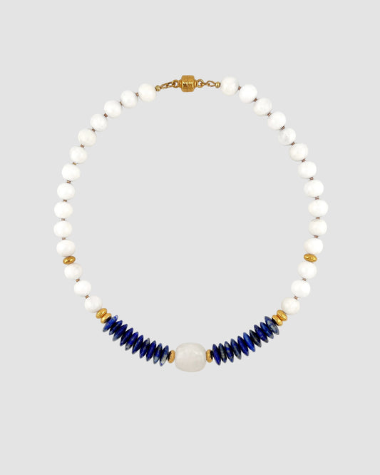 Necklace with white beads and blue accents on a light gray background