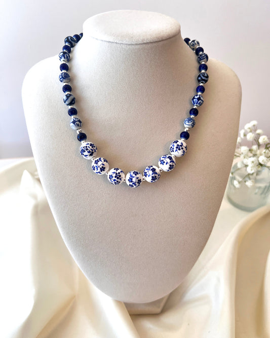 Necklace with blue and white beads on a mannequin bust against a light background