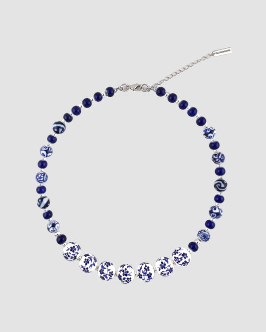 Necklace with blue and white beads on a white background