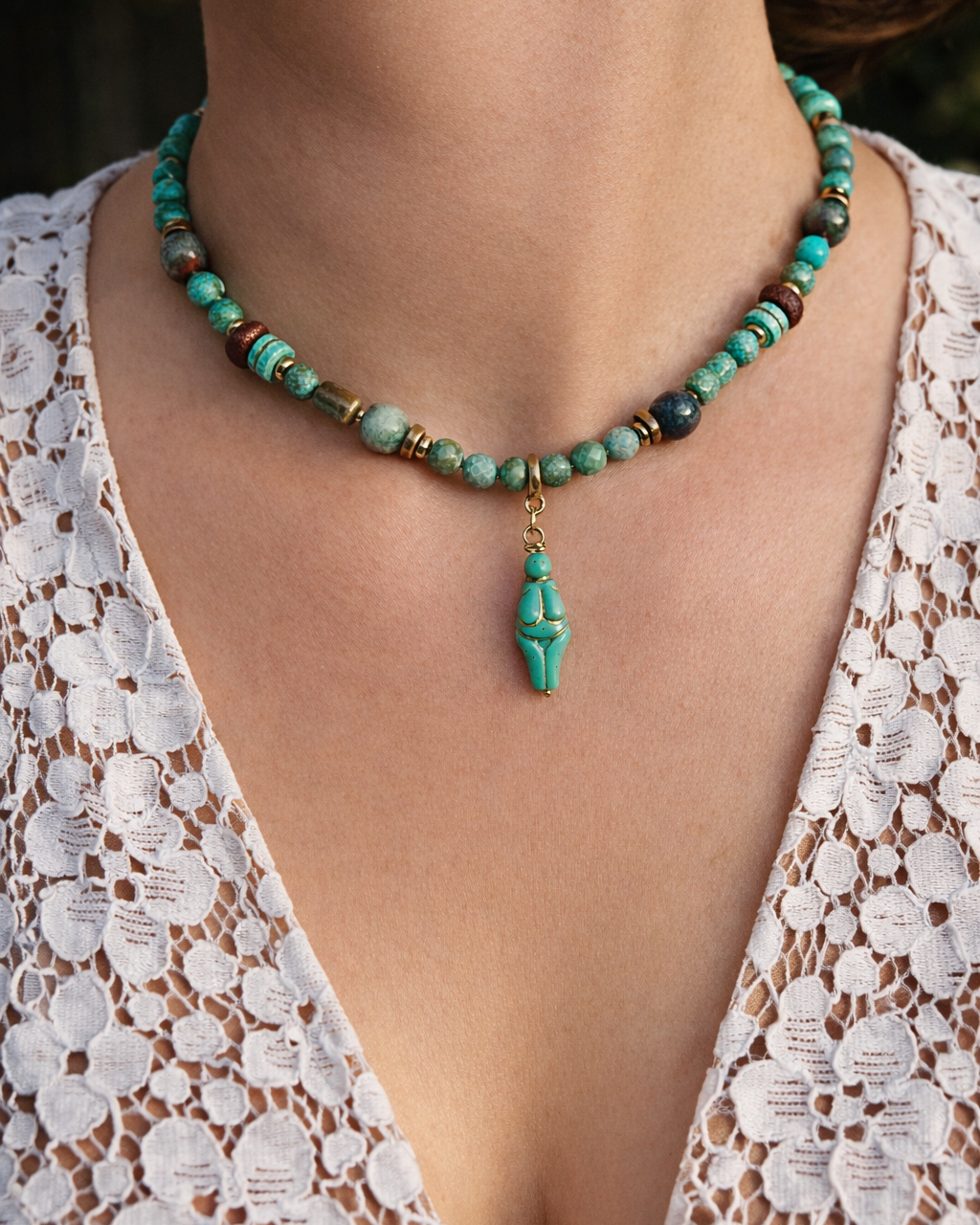 Turquoise beaded necklace worn by a person in a white lace top.