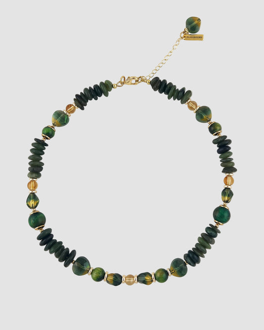 Necklace with green and gold beads on a white background