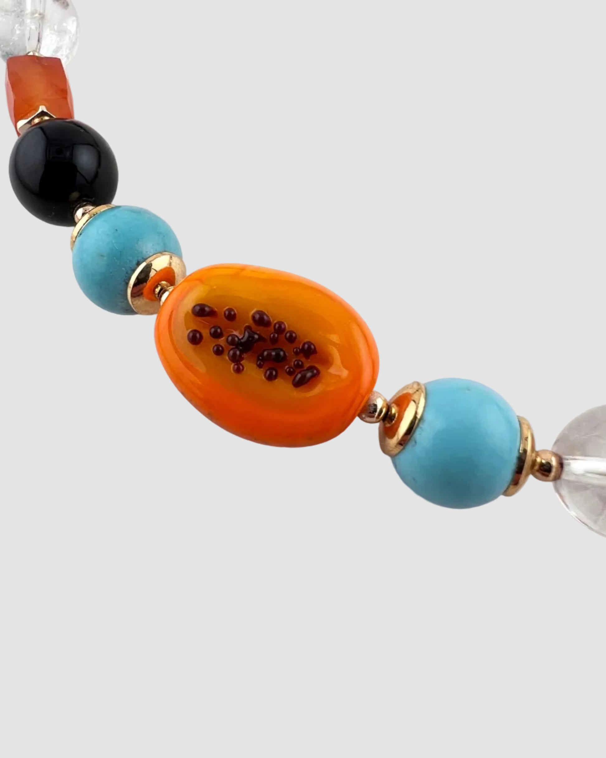 Close-up of a colorful beaded necklace on a light gray background