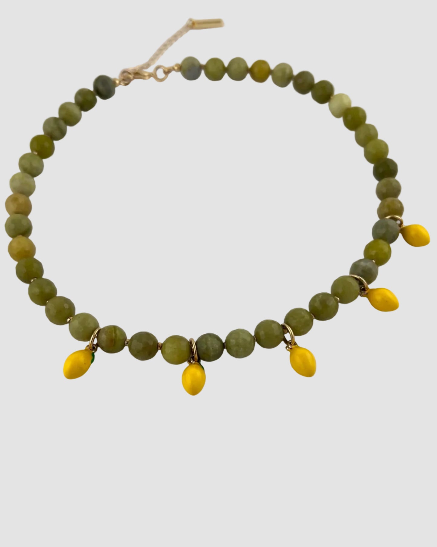 Necklace with green beads and yellow accents on a white background