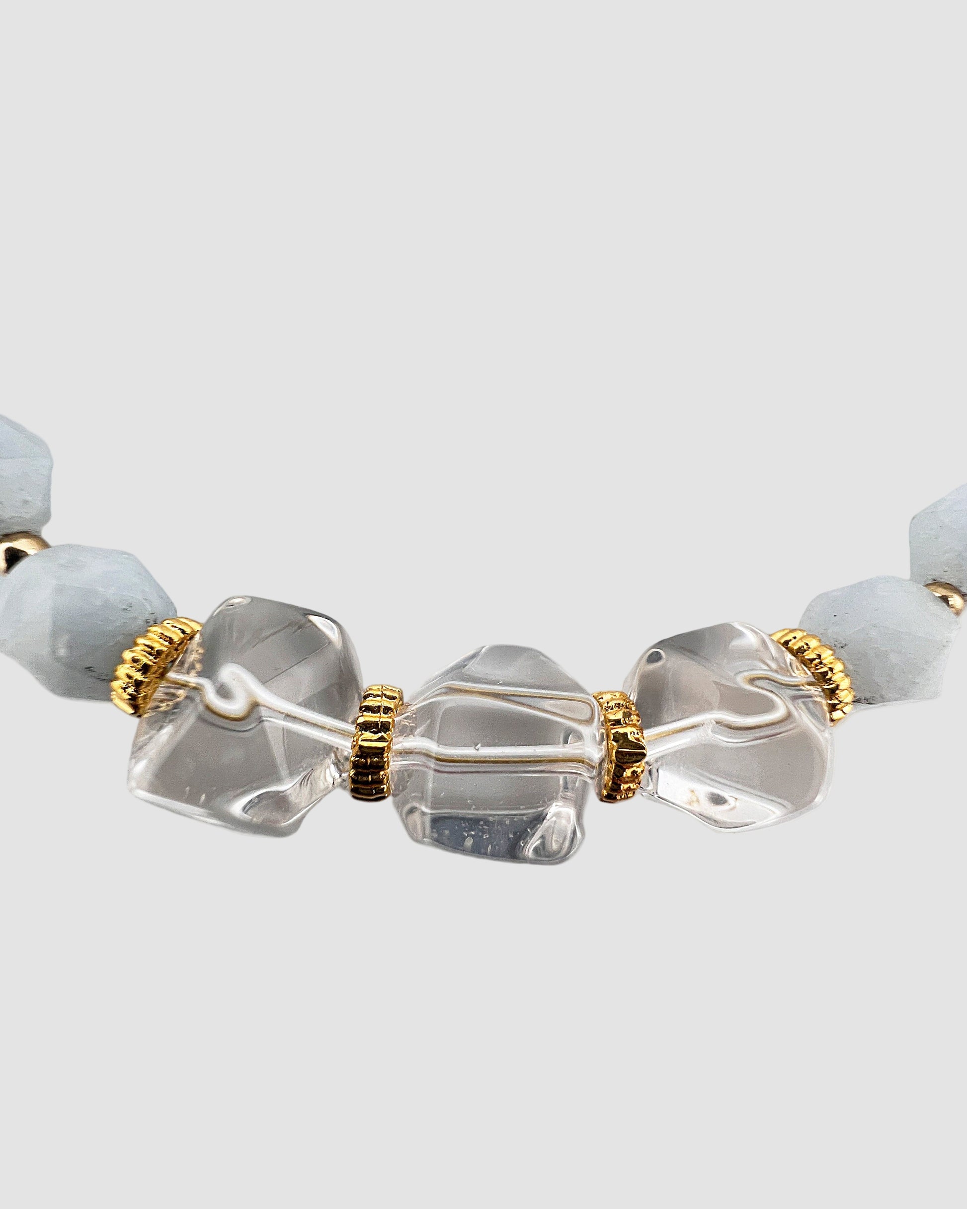 Close-up of a bracelet with clear and light blue beads on a white background