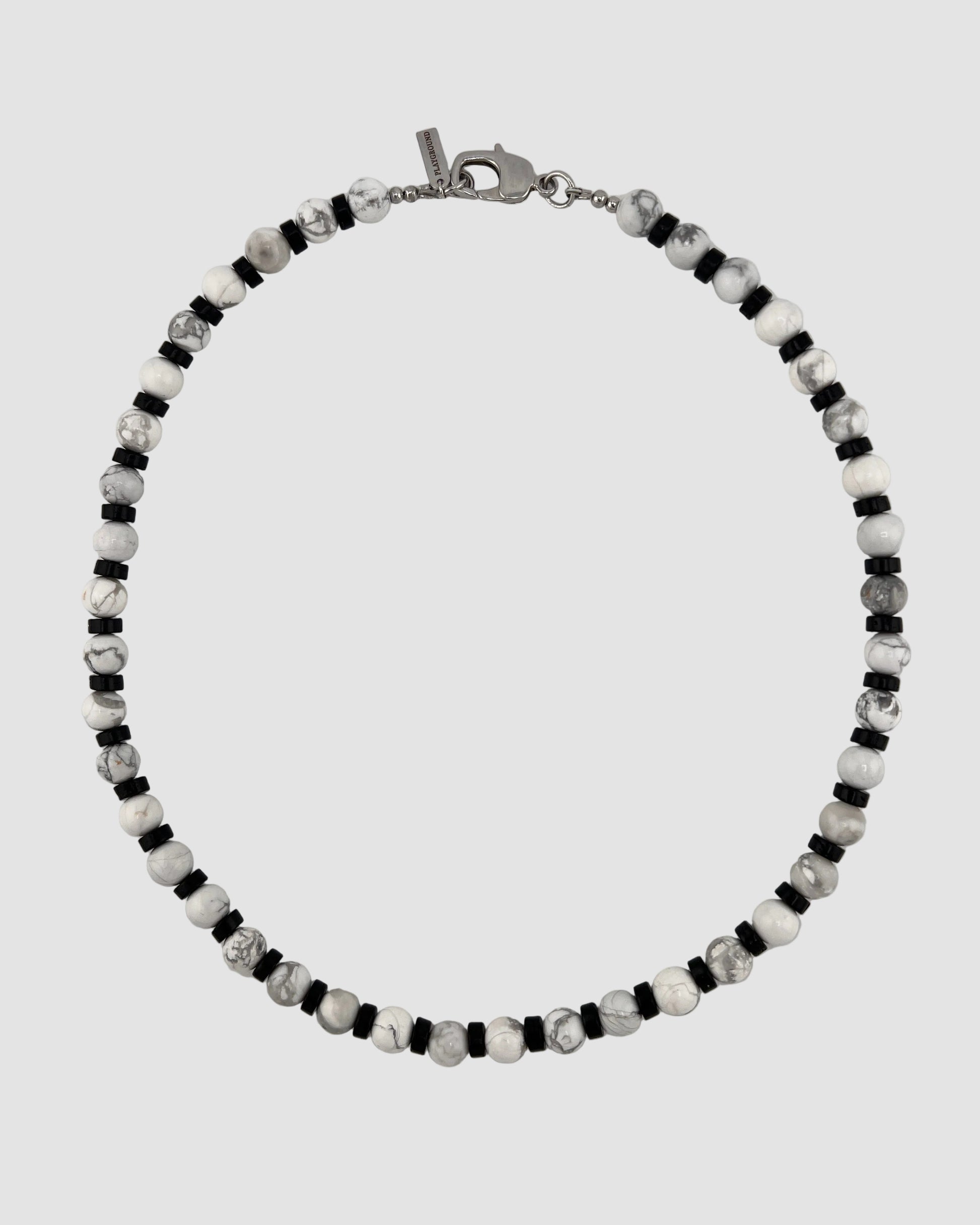 Beaded men's necklace with black, white, and gray beads on a light gray background