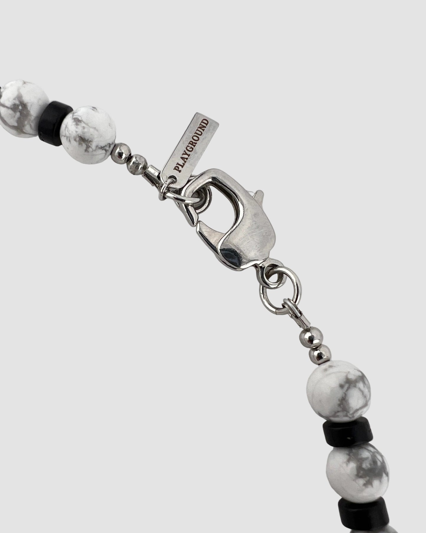 Necklace with beads and a silver clasp on a light gray background