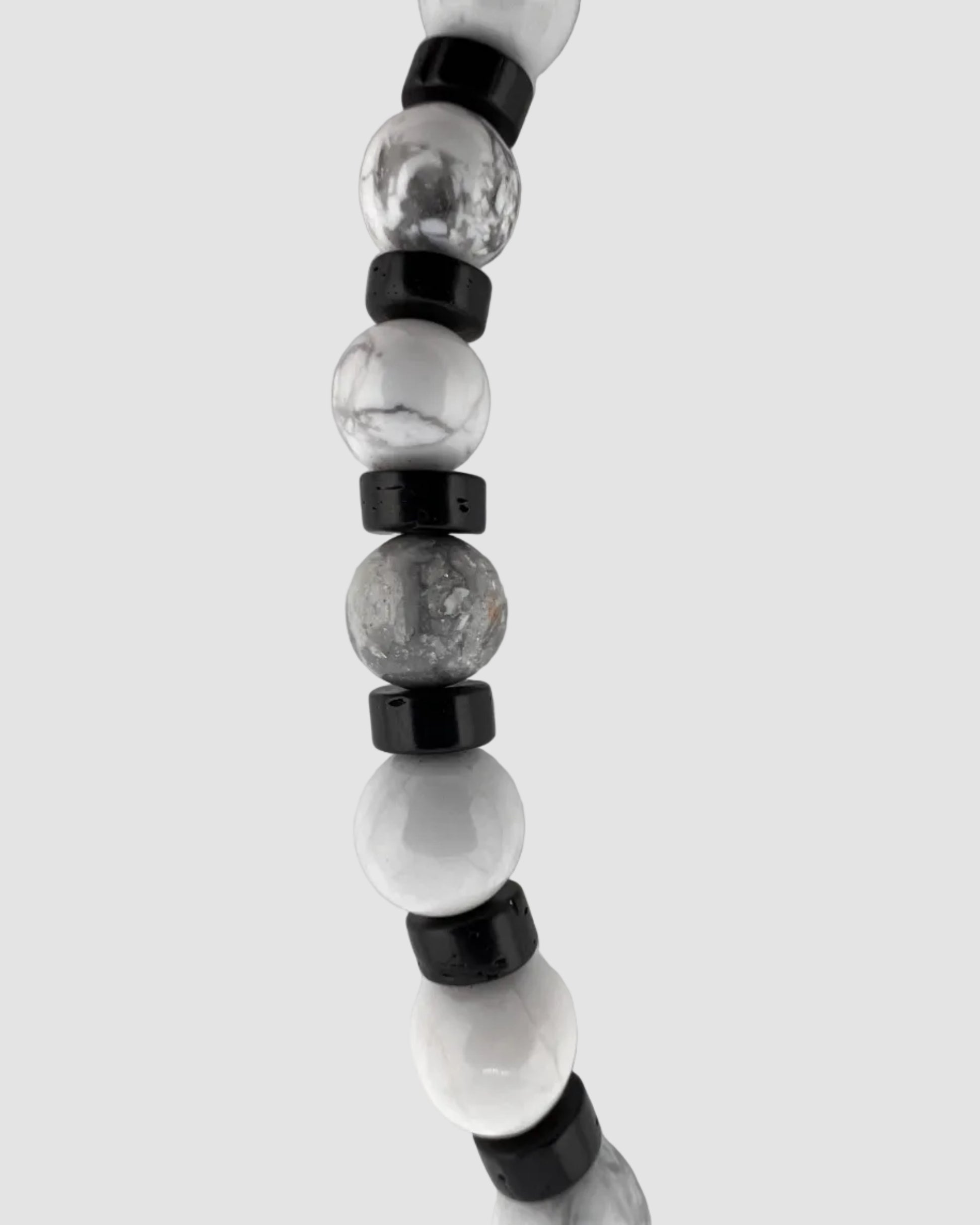Beaded necklace with black and clear beads on a light gray background