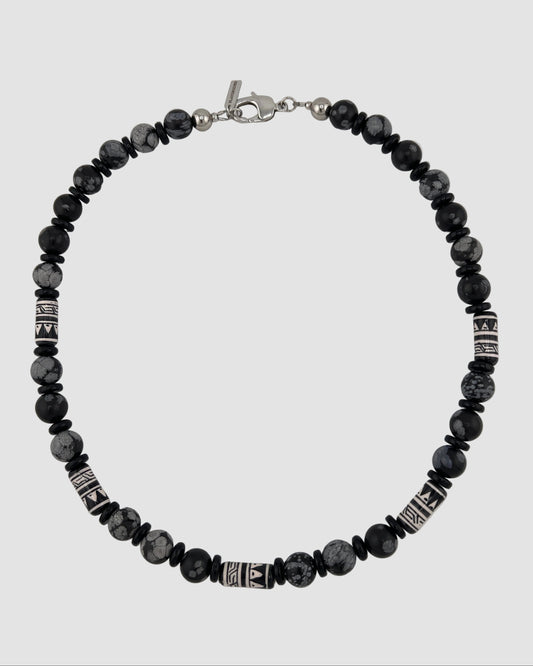 Black beaded bracelet with silver accents on a white background