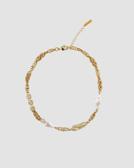 Gold necklace with pearls on a white background