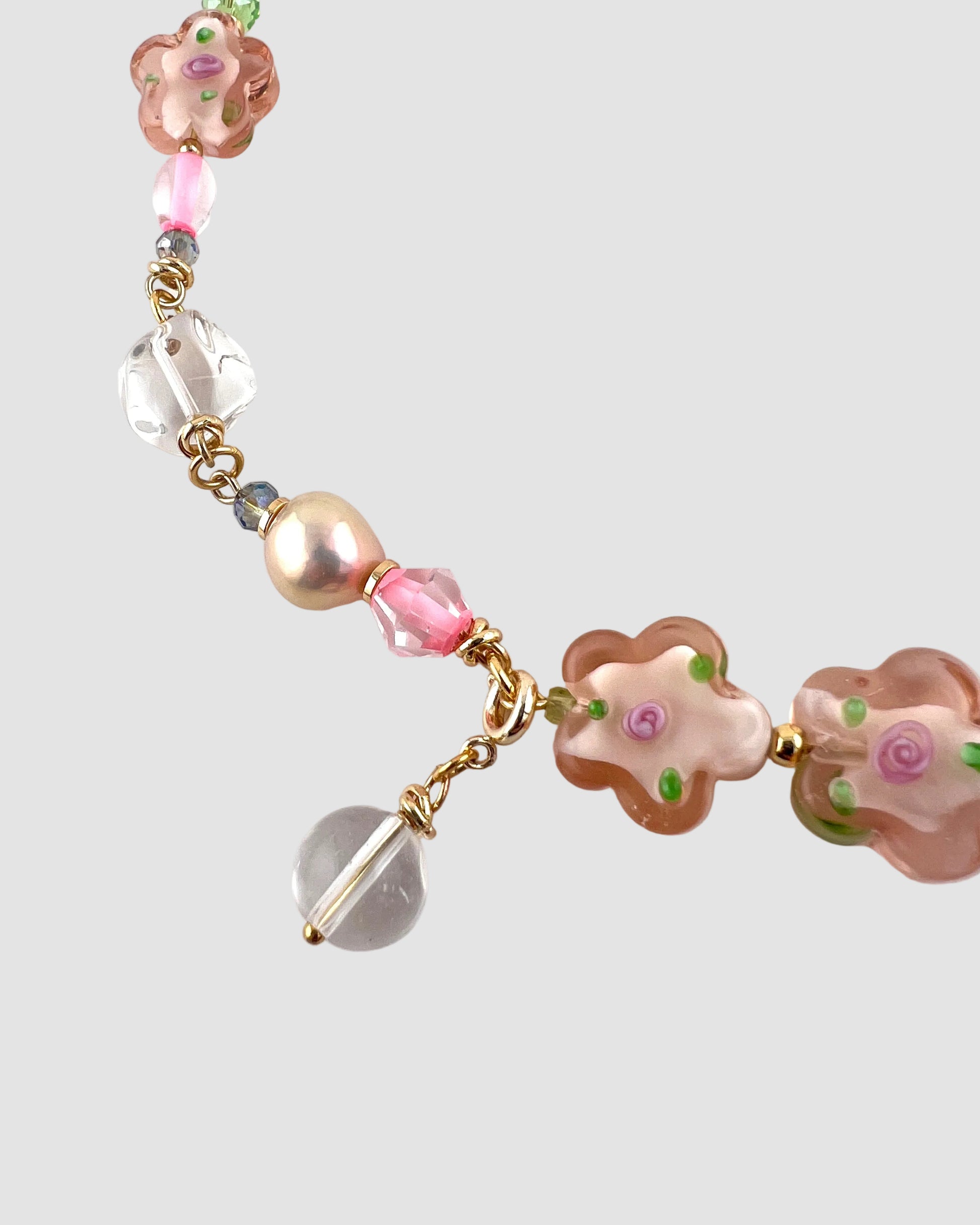 Necklace with floral beads and clear crystals on a white background