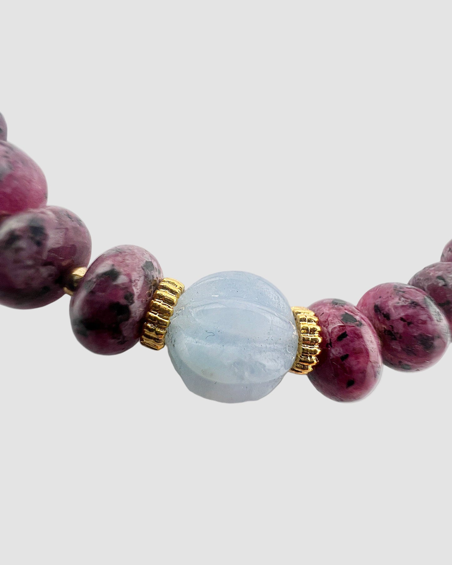 Bracelet with purple and light blue beads on a light gray background