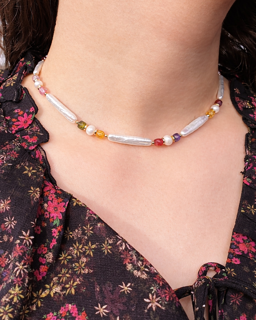 Necklace with colorful beads worn by a person in a floral dress