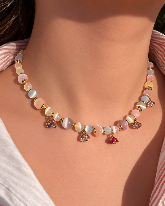 Necklace with multicolored beads on a person wearing a striped shirt.
