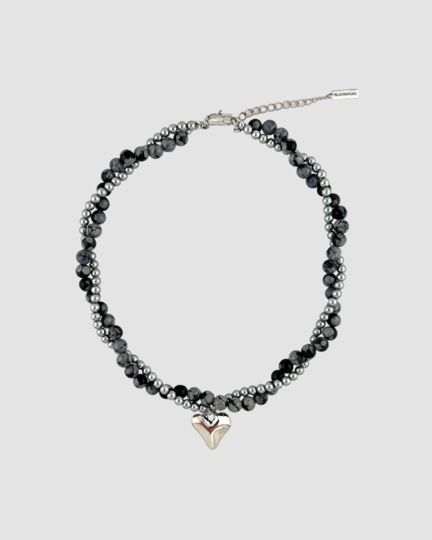 Beaded necklace with a silver heart charm on a white background