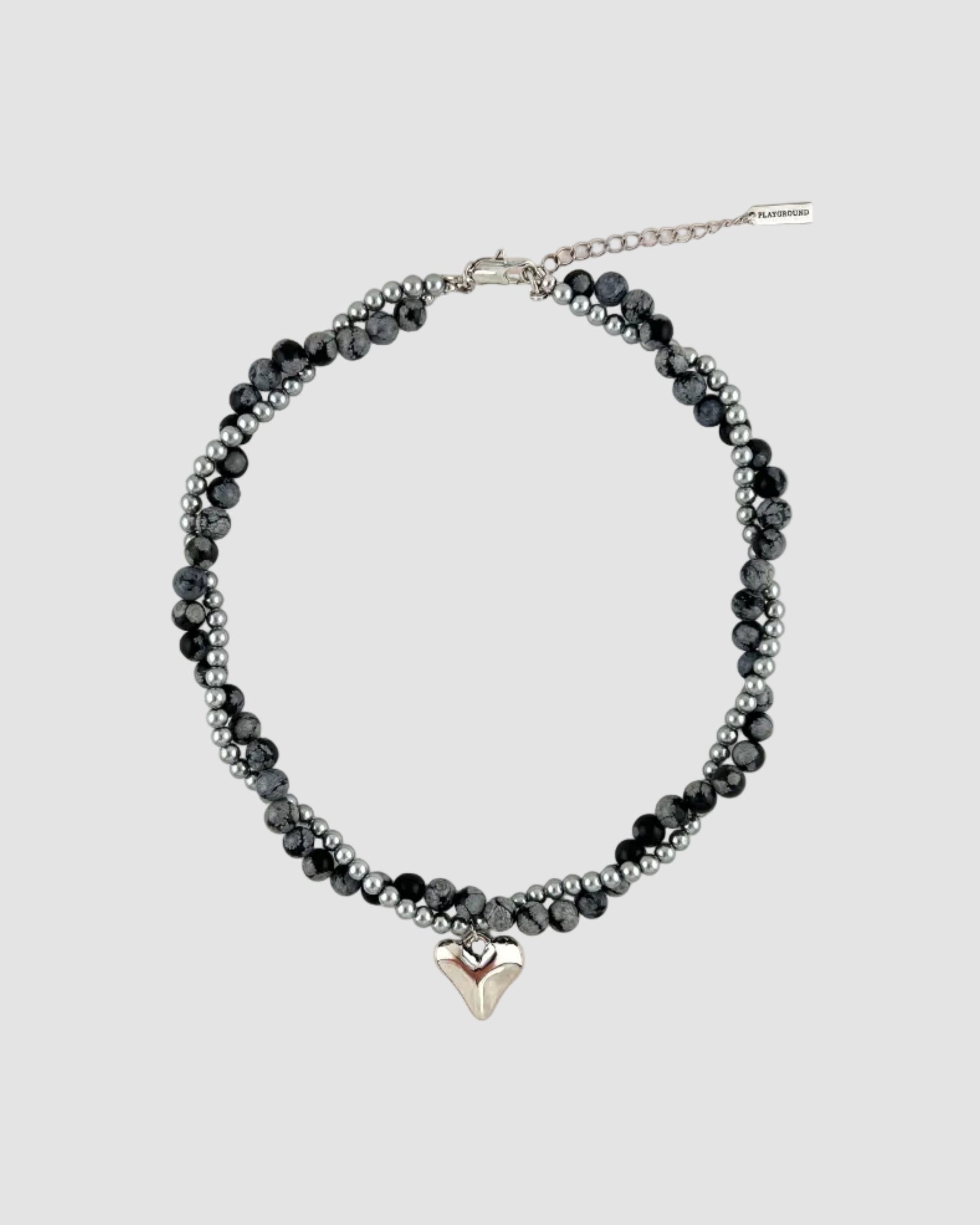Beaded necklace with a silver heart charm on a white background