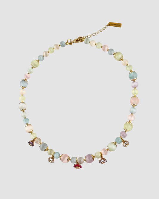 Necklace with pastel beads and small charms on a light gray background