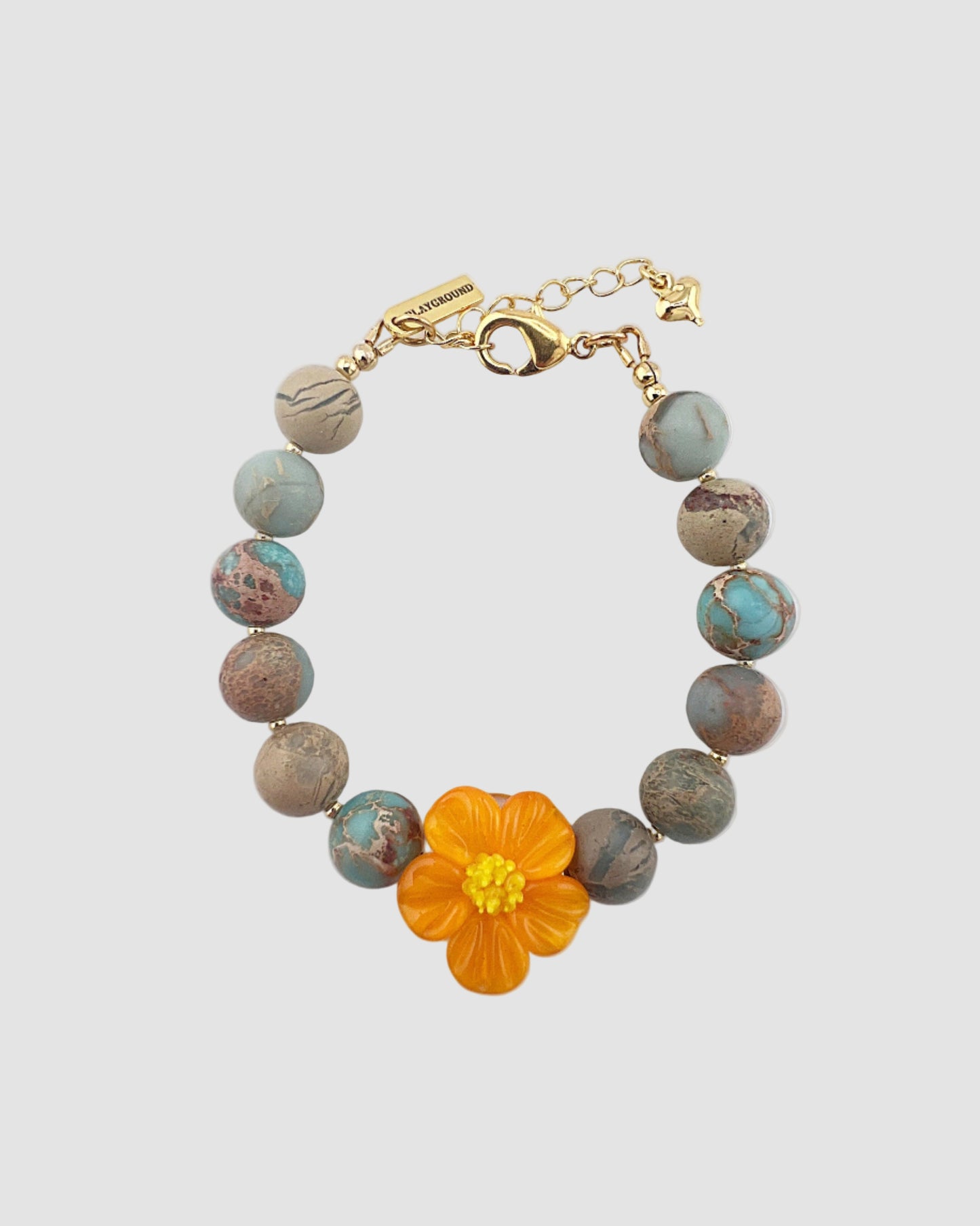 Bracelet with an orange flower charm on a light gray background