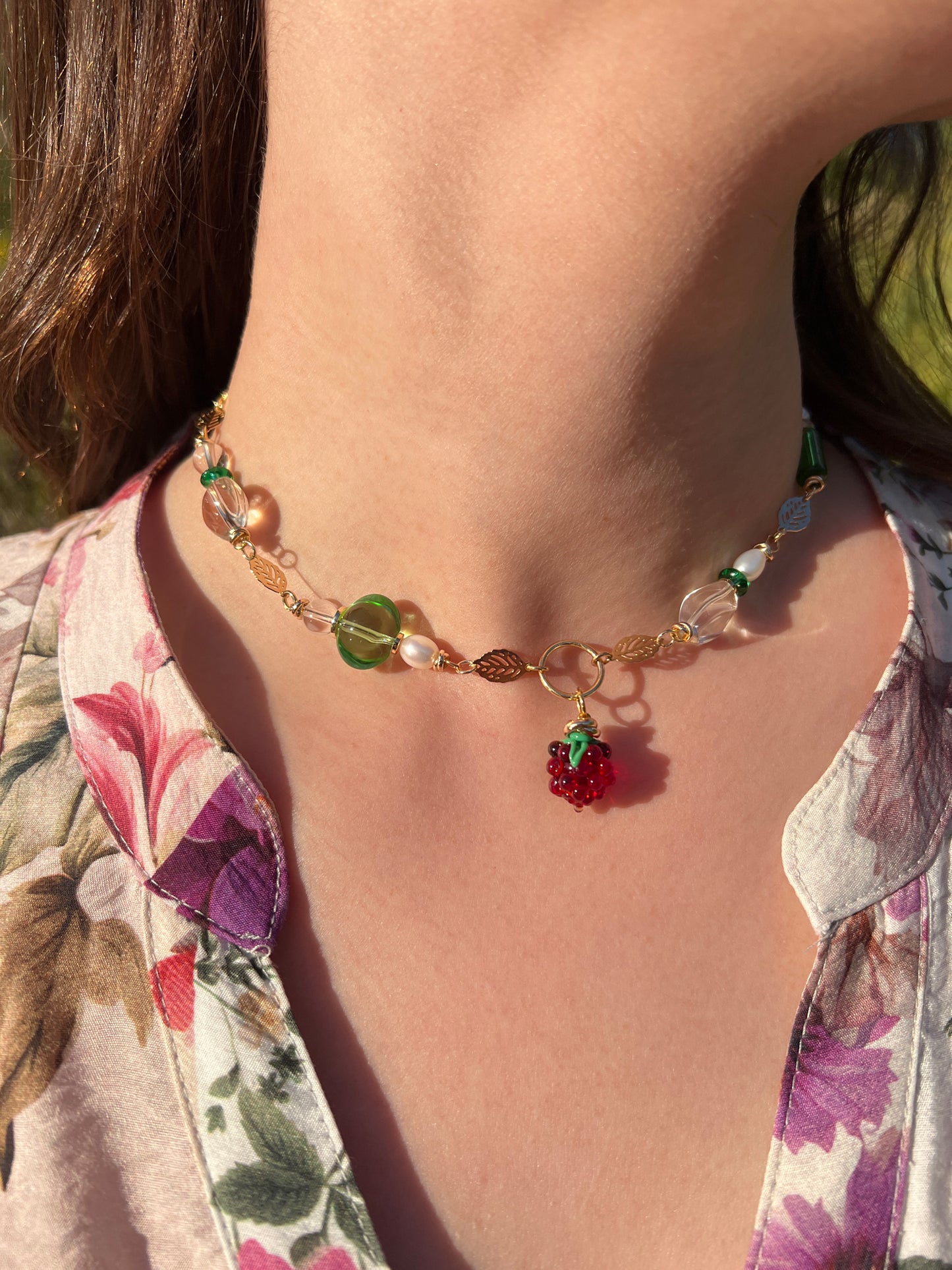 Close-up of a colorful beaded necklace with a berry charm.
